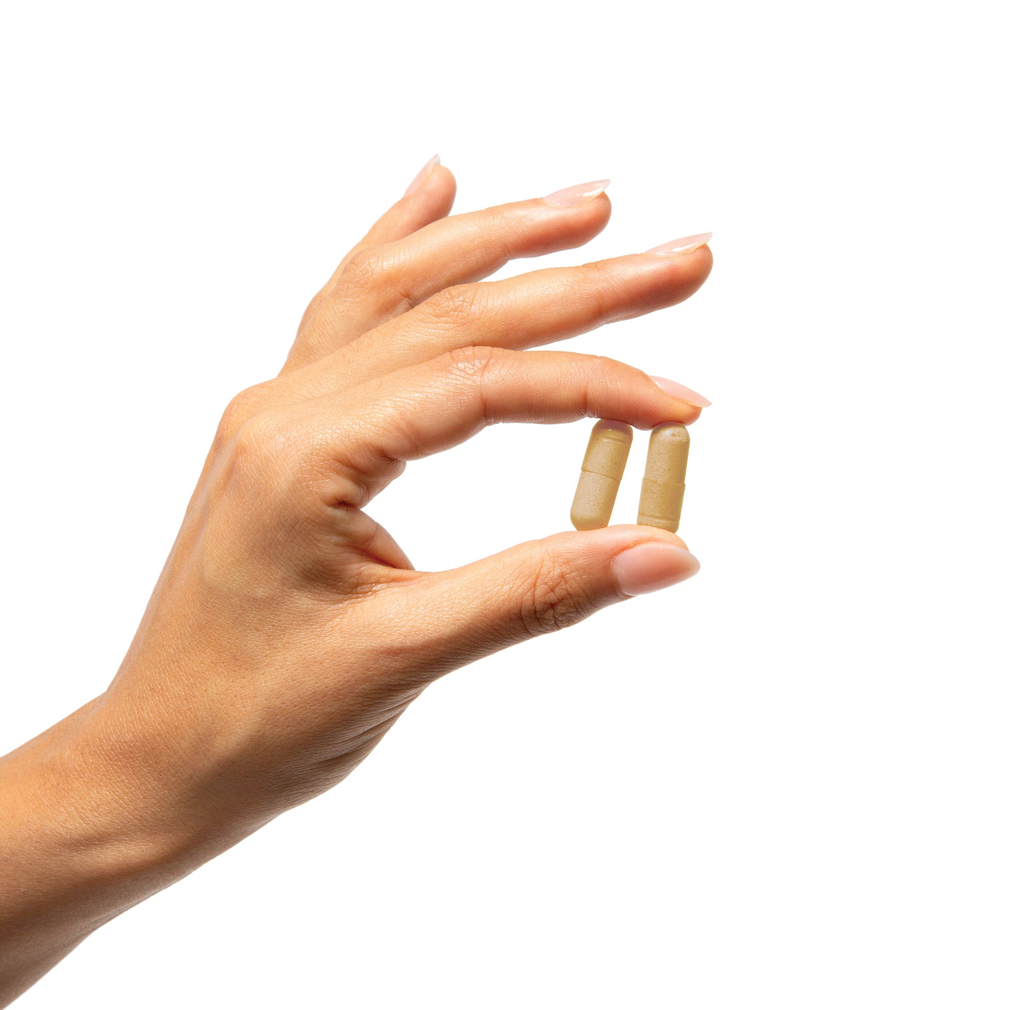 Hand holding two beige AndroSyn capsules against a white background